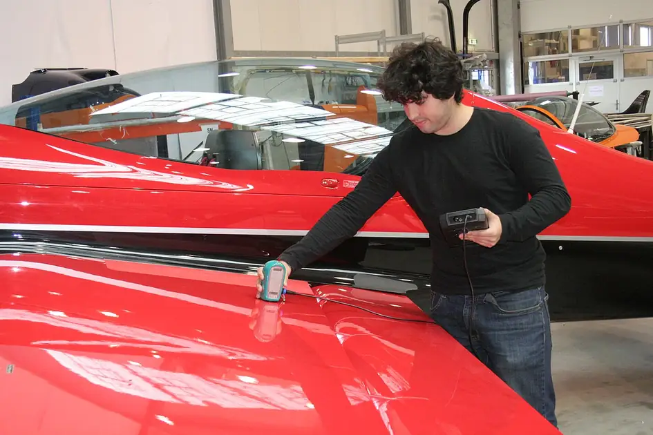 Technician using a portable inspection instrument on an aerobatic aircraft at XtremeAir